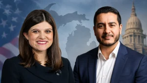 A smiling woman and man in business attire posed in front of a Michigan map and capitol building backdrop.